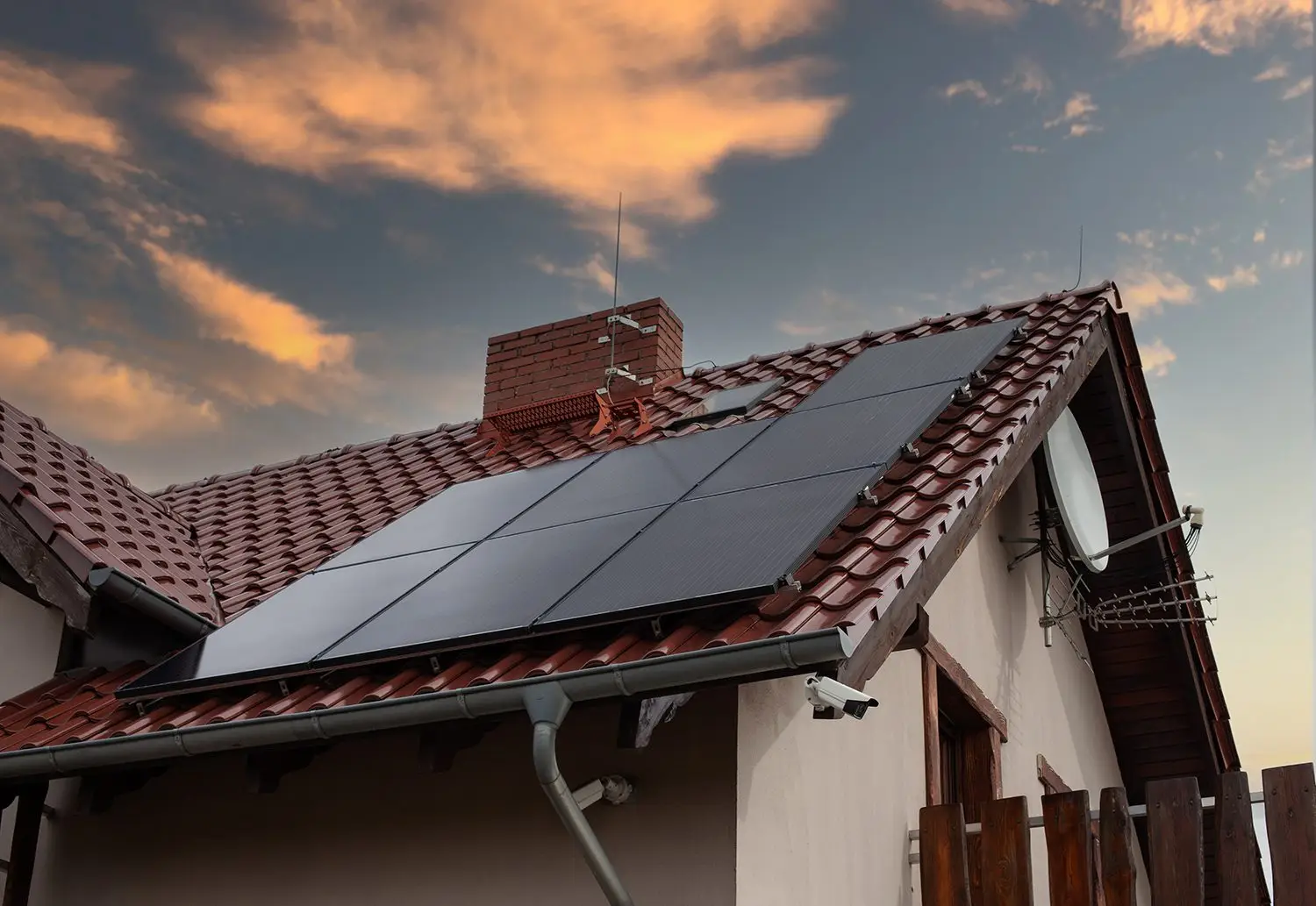 Solar panel array on tile roof at sunset