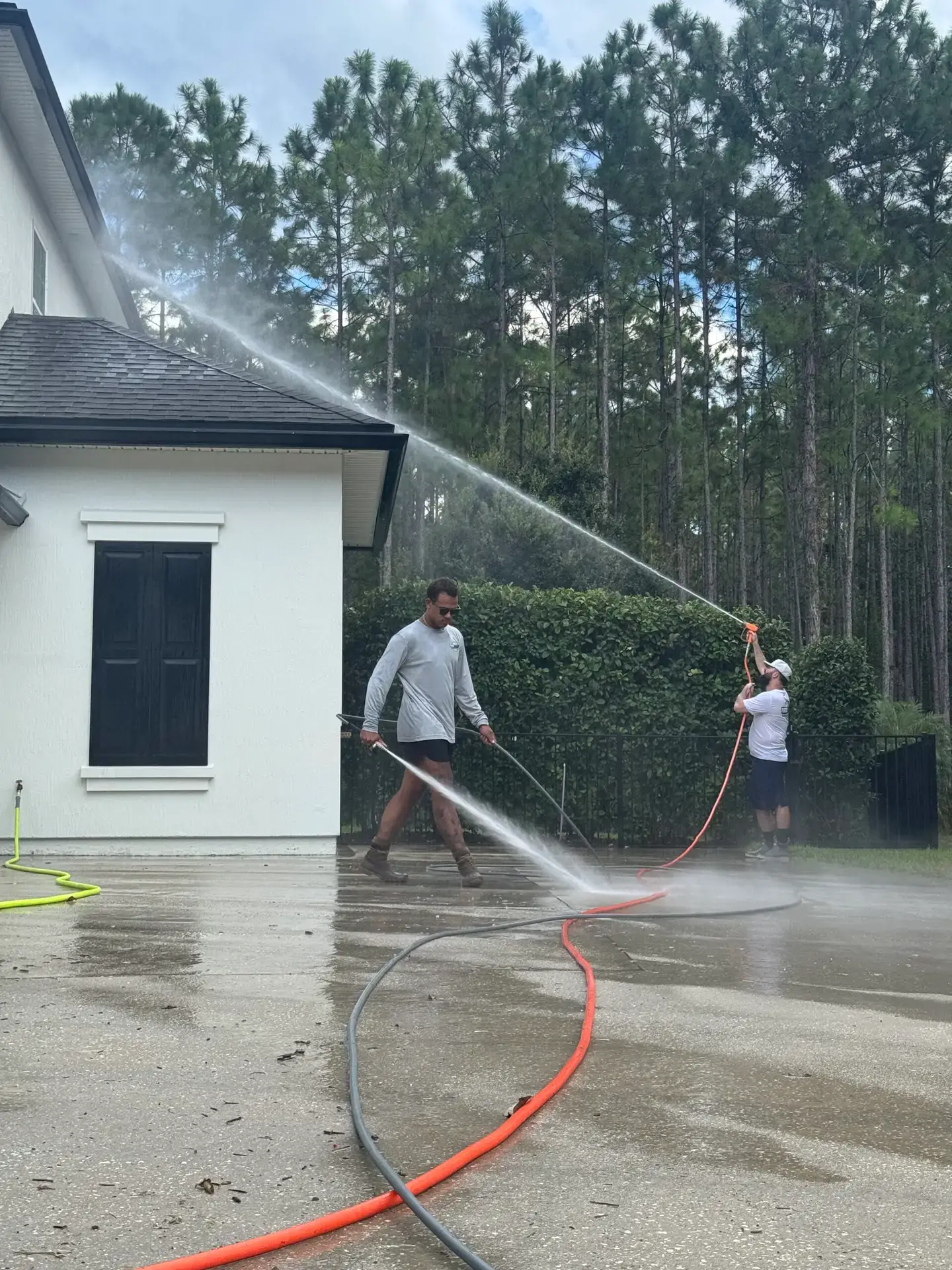 FCPE technician soft washing a two-story home in Northeast Florida