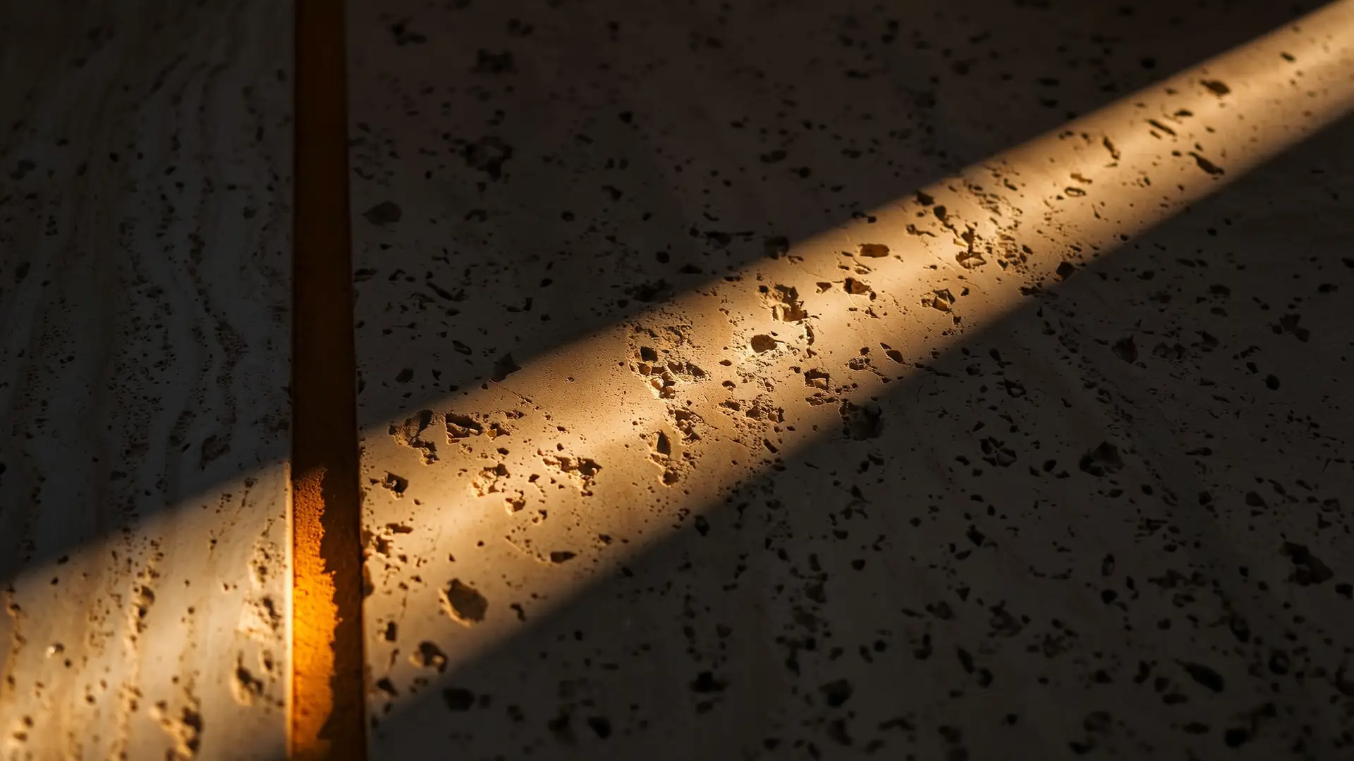Travertine paver at golden hour with joint angular sand glowing in the seal line